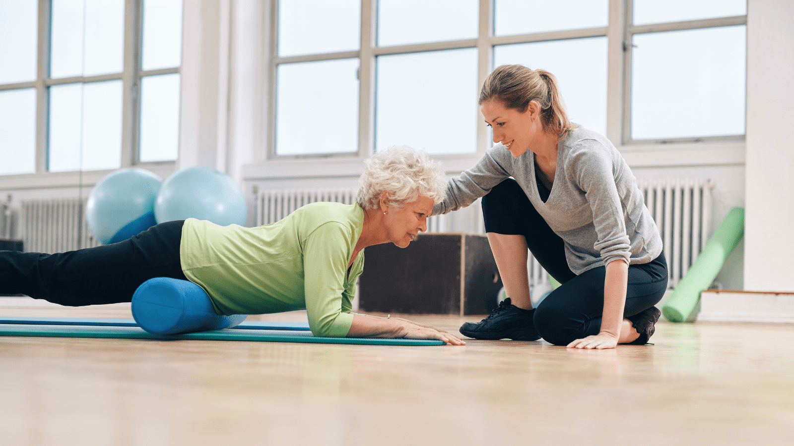 Physical therapist working with a woman in a plank to heal her.